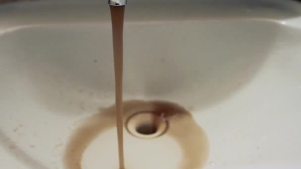 Cerca de agua contaminada marrón oxidada sucia que fluye del grifo en el lavabo del baño . — Vídeo de stock