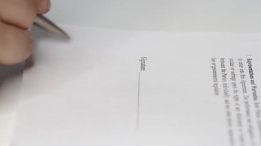 Bir iş adamının kontrat, yasal anlaşma ya da kağıt imzalarken yakın plan çekimi. Adam belgeleri imzalayarak belgeleri onaylıyor.