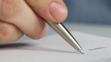 Bir iş adamının kontrat, yasal anlaşma ya da kağıt imzalarken yakın plan çekimi. Adam belgeleri imzalayarak belgeleri onaylıyor.