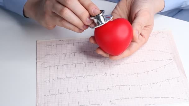 Кардиолог Проверяет Сердцебиение Игрушечного Красного Сердца Фонендоскоп Стетоскоп Кардиограмма Здравоохранение — стоковое видео