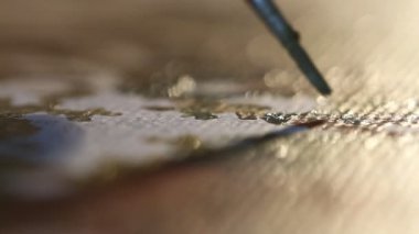 Sanatçı fırçasına yakın çekim. Resim stüdyosunun arka ışıklarındaki tuvale resim yapmak. Modern sanat eseri yaratmak. Hobi ve eğlence konsepti