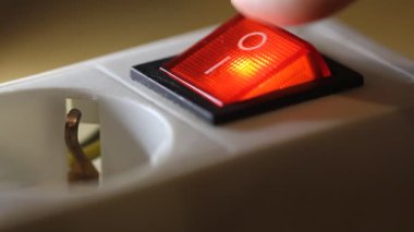 Female finger presses the red on/off power button. Close up video, selective focus