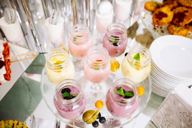 Güzel dekore edilmiş yemek masası pembe masa örtüsü üzerine smoothie.