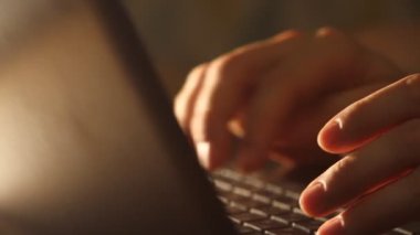 Close up shot of man typing on laptop keyboard; backlit; news, writer, media or communication concept