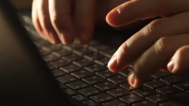 Close up shot of man typing on laptop keyboard; backlit; news, writer, media or communication concept