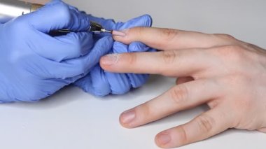 Erkek tırnaklarıyla ilgilenmek. Salondaki mavi eldivenli manikürcü bir erkek için manikür yapıyor. Erkeklerin güzellik konsepti