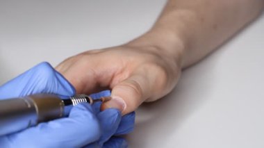 Erkek tırnaklarıyla ilgilenmek. Salondaki mavi eldivenli manikürcü bir erkek için manikür yapıyor. Erkeklerin güzellik konsepti