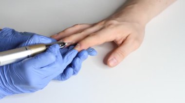 Erkek tırnaklarıyla ilgilenmek. Salondaki mavi eldivenli manikürcü bir erkek için manikür yapıyor. Erkeklerin güzellik konsepti