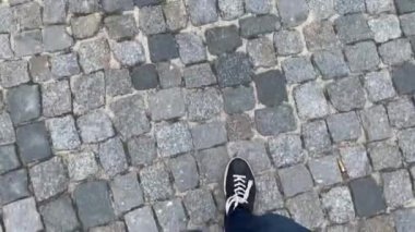 Siyah spor ayakkabılı ayaklar sett yol üzerinde adım şehir üzerinde yürüyor