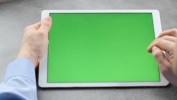 男は緑の画面でタブレットの画面に触れ 見ています ビジネスマンの手にタブレットの画面上のクロマキー — ストック動画