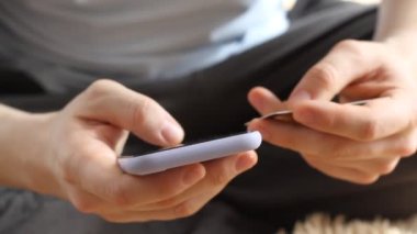 Kredi kartıyla alışveriş yapan adam. Çevrimiçi bankacılık ve akıllı telefon. Adam banka kartı numarasına giriyor. Ellerinizi kapatın. Yaşam tarzı teknolojisi ve e-posta konsepti