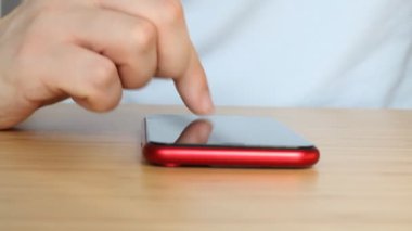 Sosyal medyada akıllı telefon kullanan, kaydırma, kaydırma hareketleri yapan bir adam. Cep telefonlu erkek mesajlaşması.