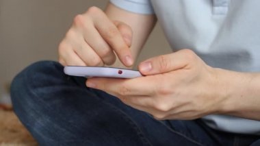 Sosyal medyada akıllı telefon kullanan, kaydırma, kaydırma hareketleri yapan bir adam. Cep telefonlu erkek mesajlaşması.