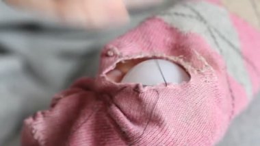 Kadın pembe çoraplarda delikler açıyor. El yapımı dikiş. Yoksulluk ve dilencilik kavramı. 