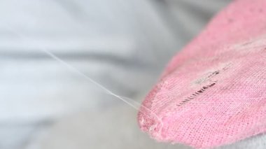 Kadın pembe çoraplarda delikler açıyor. El yapımı dikiş. Yoksulluk ve dilencilik kavramı. 