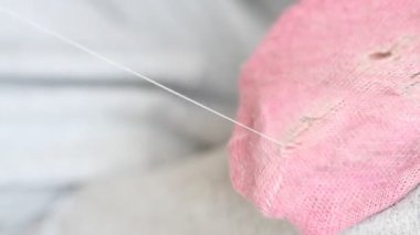 Kadın pembe çoraplarda delikler açıyor. El yapımı dikiş. Yoksulluk ve dilencilik kavramı. 
