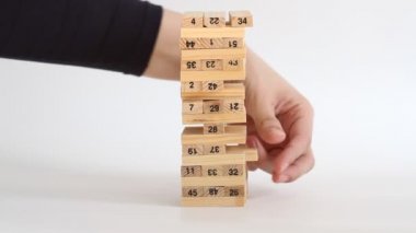 Kadın ve erkek beyaz arka planda jenga oynuyor. Aile eğlencesi ve tatil konsepti.