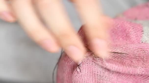 女人在粉红的袜子上缝洞 手工缝纫 贫穷和乞讨的概念 — 图库视频影像