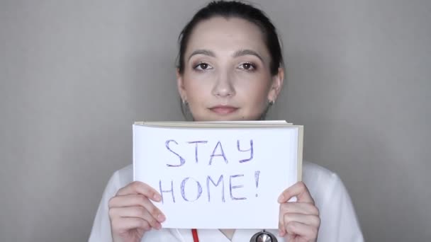 ウイルス学者 科学者は家にとどまる印が付いているポスターを示し 家にとどまるように頼む 自宅の隔離 予防Covid コロナウイルス発生状況 — ストック動画