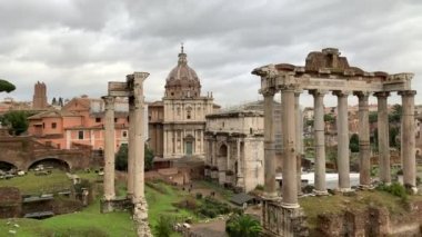 Roma, İtalya 28 Ocak 2020 'de kurulmuş. Antik Roma Forumu 'nu harabeye çevirdi. Turistler yağmurlu bir günde İtalya 'nın merkezindeki Roma forumunda yürürler. Tarihsel Avrupa mimarisi.