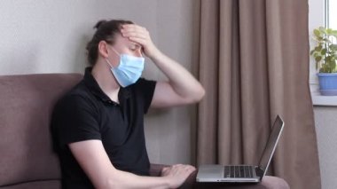 Koruyucu yüz maskesi takan genç blogcu cep telefonuyla video kaydediyor. Erkek blogcu Coronavirus salgınıyla ilgili yayın yapıyor. Kendini karantinaya almak için evde kal.