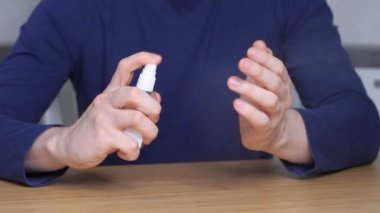 Adam antiseptik şişeyle elini temizliyor. Bakteri ve virüsün yayılmasını önleme, covid-19 ve coronavirüs. Temizleyici sprey ve kişisel hijyen konsepti