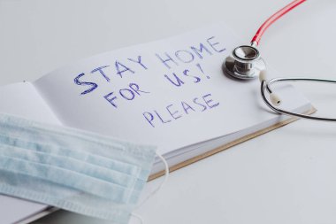 Ev tabelası, steteskop ve maskeli bir poster. Ev karantinası, COVID-19 önleme, Coronavirüs salgını