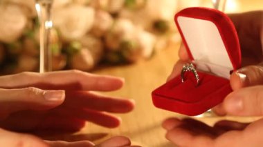 Evlilik teklifini yakından çek. Erkek, evlenme teklif eden kadına elmas yüzük verir. Kapalı mekanda ya da evde romantik bir akşam yemeği.