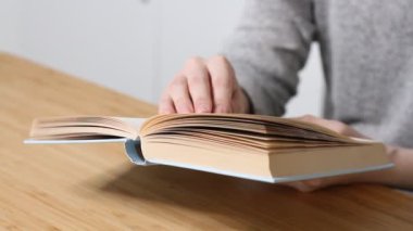 Oturma odasında kitap okuyan, sayfayı çeviren, öğrenen, eğitim alan, kitap okuyan, evde kalan genç bir kadın..