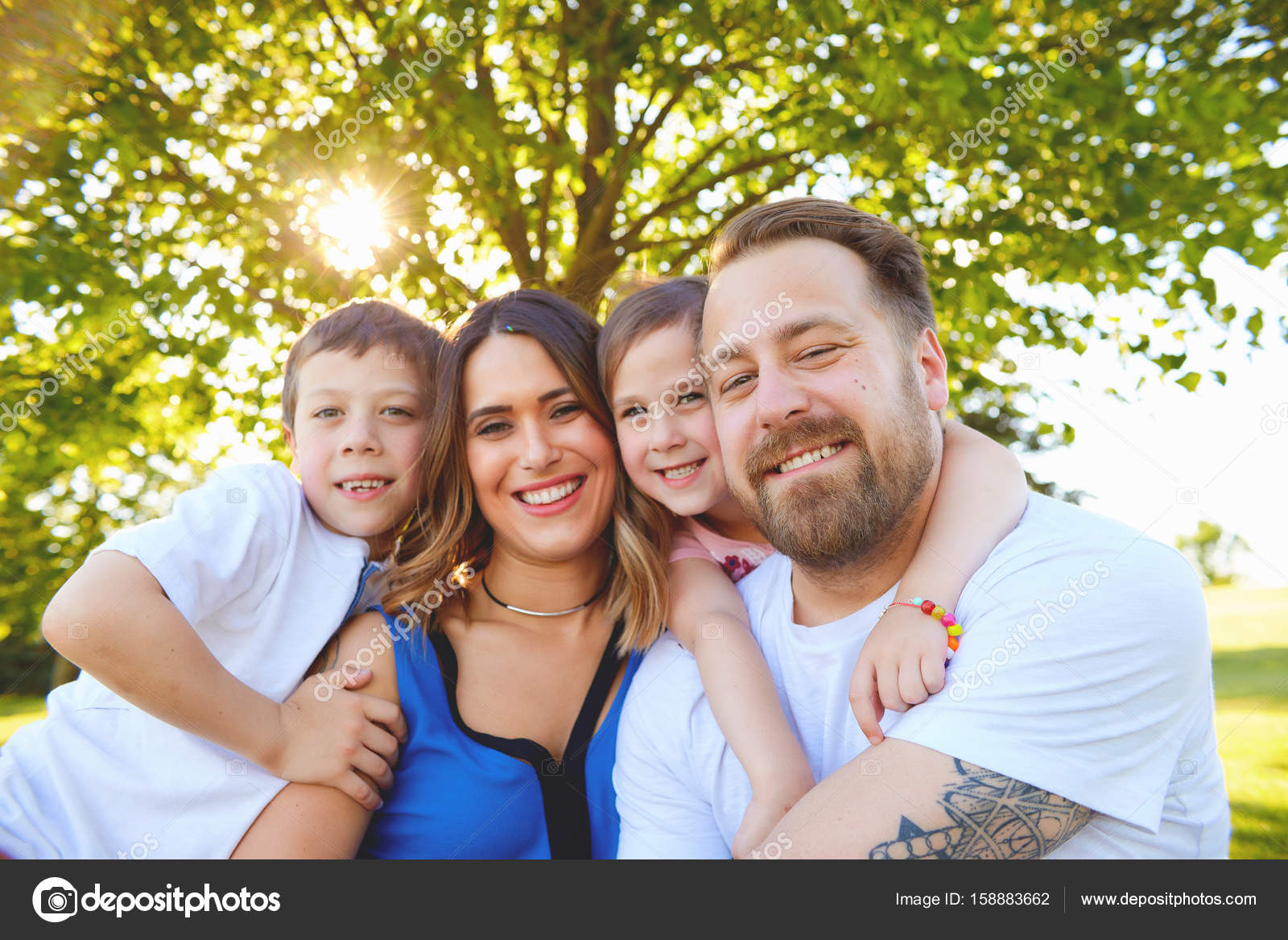 Cheerful family posing embracing in summer — Stock Photo