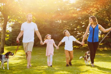Mutlu aile köpeklerle yürümek ve konuşmak