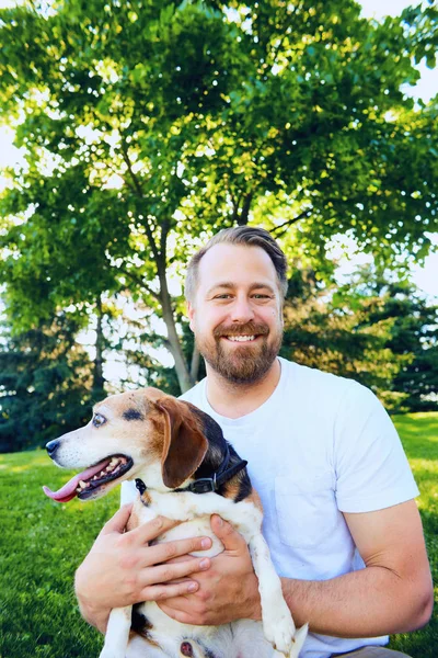 Porträt eines glücklichen bärtigen Mannes, der seinen Hund umarmt — Stockfoto