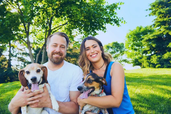 Gülümseyen çift onların köpekleri ile yaz aylarında poz — Stok fotoğraf