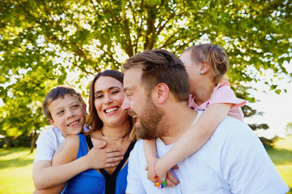 Porträt einer glücklichen Familie, die im Sommerpark lacht — Stockfoto