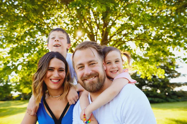 Glückliche kleine Kinder, die ihre Eltern umarmen — Stockfoto