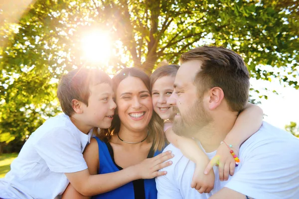 Birlikte oturan neşeli aile yaz aylarında kucakladı