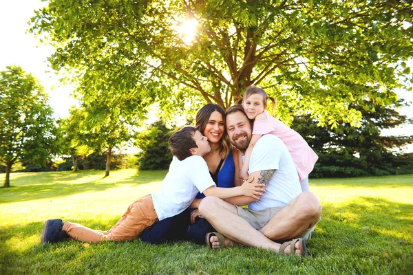 幸福的家庭，与孩子们坐在树下 — 图库照片
