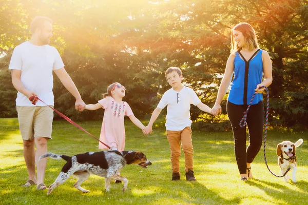 Famille joyeuse marchant avec des chiens dans le parc — Photo