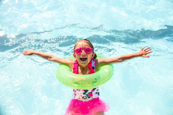 Happy little girl wearing flotation ring in pool — Stock Photo, Image