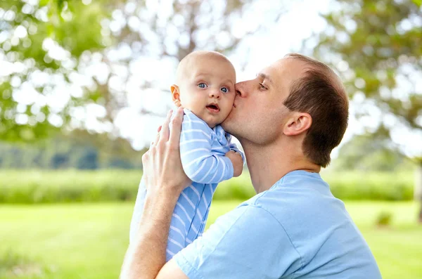 Retrato do jovem pai beijando seu filho recém-nascido — Fotografia de Stock