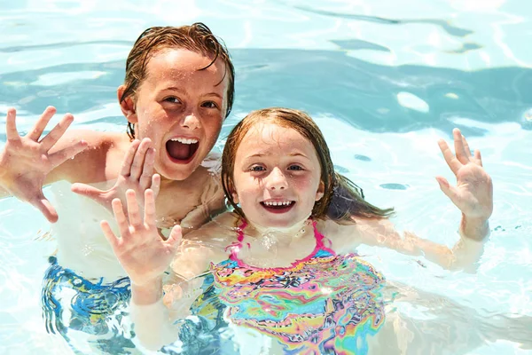 Happy little children swimming in pool together — Stock Photo, Image
