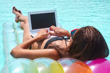 Havuzu Sala Resort yatan dizüstü kullanan kadın