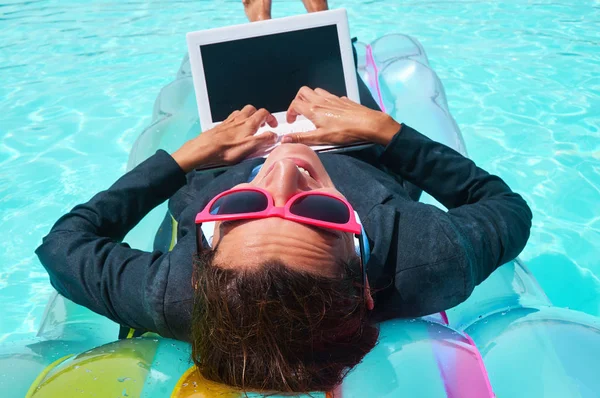 İşkadını havuzu içinde laptop üzerinde gülümseyen