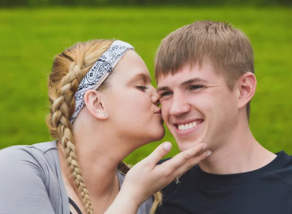 Junges liebes Mädchen küsst ihren Freund auf die Wange — Stockfoto