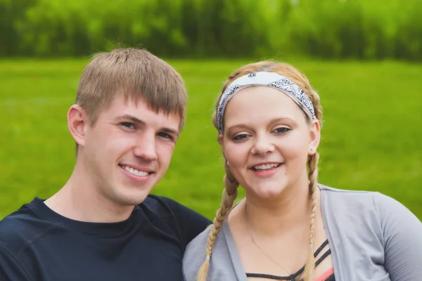 Glückliche Gesichter eines jungen Paares, das in die Kamera lächelt — Stockfoto