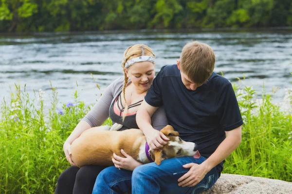 Genç çift onların köpek okşamaya gülümseyen portresi — Stok fotoğraf