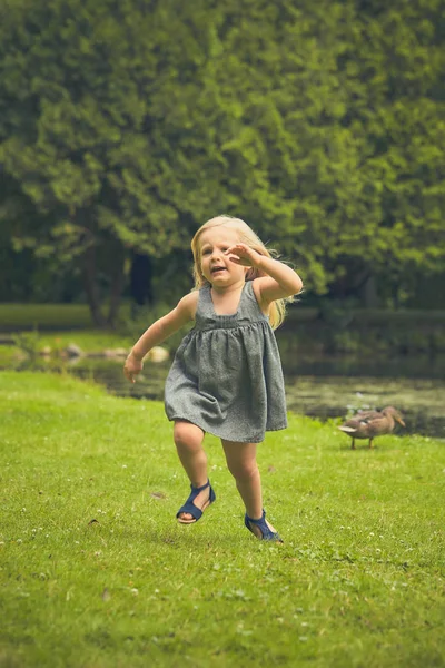 Portrait of happy little girl running in summer — Stock Photo, Image