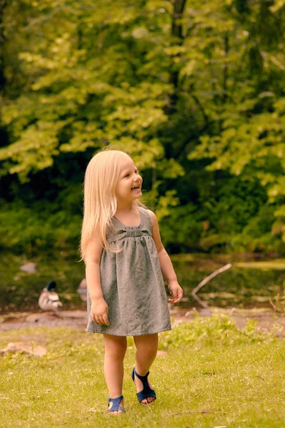 Happy little girl in dress walking in summer — Stock Photo, Image