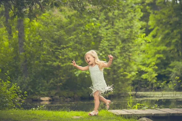 Happy little girl running in forest in summer — Stock Photo, Image