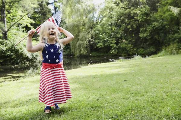 Neşeli küçük kız Amerikan bayrağı yürüyüş